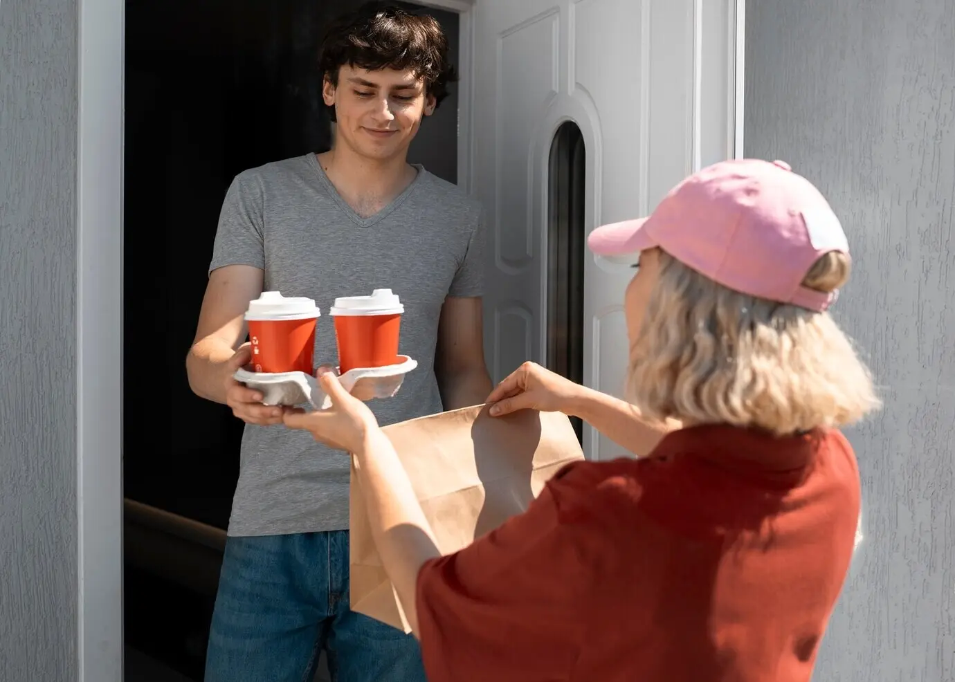 Вид сбоку: мужчина берет кофейные чашки.